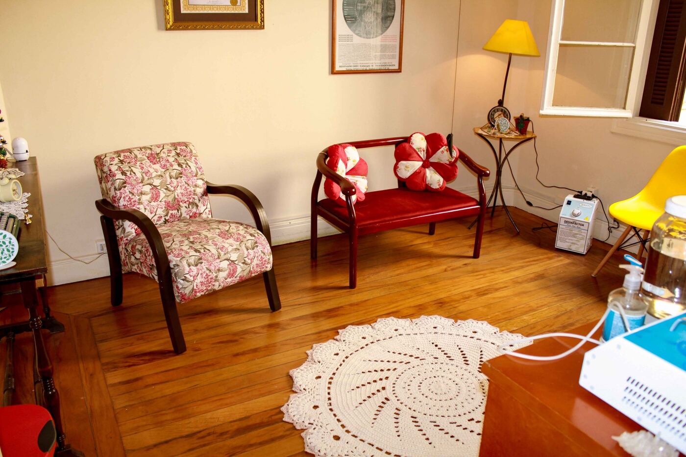 Sala de espera com poltrona florida e banco vermelho